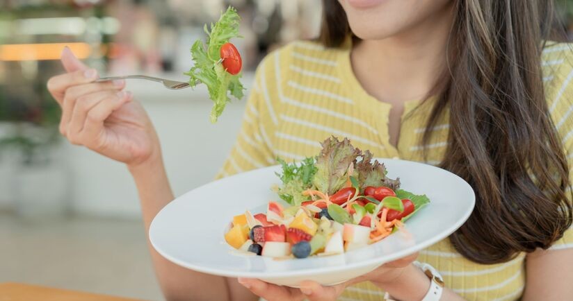 dieta na piękną cerę, dieta na piękną skórę, kobieta je sałatkę owocową