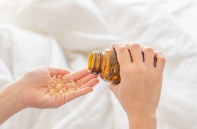 Kapsułki z olejem z rekina na dłoni. Olej z rekina, olej z wątroby rekina.