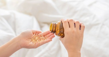 Kapsułki z olejem z rekina na dłoni. Olej z rekina, olej z wątroby rekina.