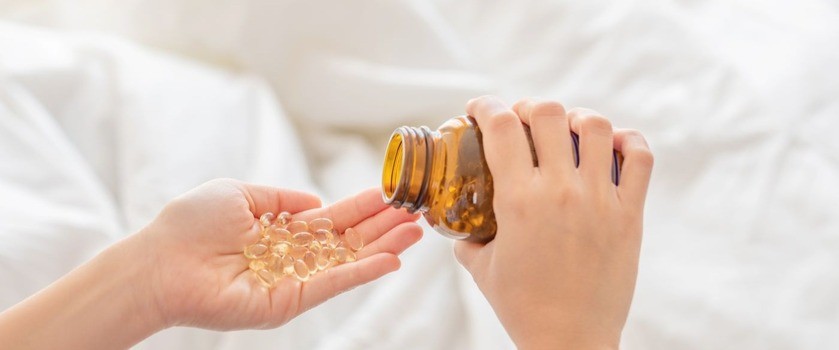 Kapsułki z olejem z rekina na dłoni. Olej z rekina, olej z wątroby rekina.