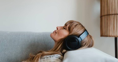 leżąca kobieta w słuchawkach na uszach