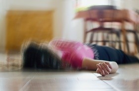 Kobieta leżąca na podłodze w napadzie padaczkowym