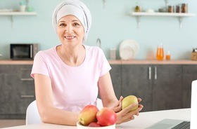 Kobieta po chemioterapii z jabłkami w ręku. Dieta po chemioterapii, dieta podczas chemioterapii, dieta przy chemioterapii.