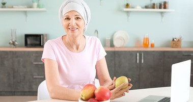 Kobieta po chemioterapii z jabłkami w ręku. Dieta po chemioterapii, dieta podczas chemioterapii, dieta przy chemioterapii.