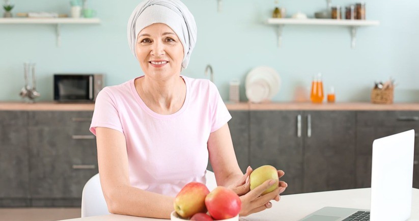 Kobieta po chemioterapii z jabłkami w ręku. Dieta po chemioterapii, dieta podczas chemioterapii, dieta przy chemioterapii.