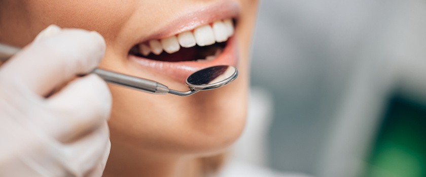 Kobieta pokazuje szkliwo zębów u dentysty