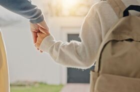 dziecko wraz z mamą przed budynkiem szkoły, pierwsze dni w przedszkolu