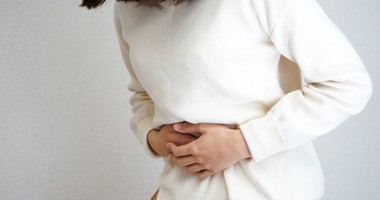 kobieta trzymająca się za bolący żołądek