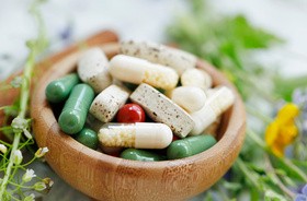 Garść suplementów diety, jako kolorwe kapsułki i tabletki