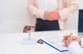 Pacjentka u lekarza, na stole model ludzkiej wątroby. Rośnie liczba zakażeń WZW typu A w Polsce i Czechach.