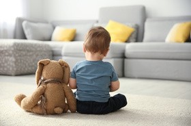 Dziecko z autyzmem siedzi na podłodze