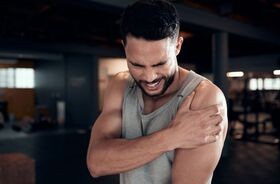 mężczyzna odczuwający ból mięśni po treningu, zakwasy, doms, domsy