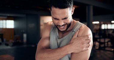 mężczyzna odczuwający ból mięśni po treningu, zakwasy, doms, domsy