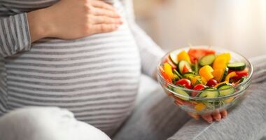 dieta w ciąży, czego nie jeść w ciąży - lista produktów, kobieta w ciąży trzyma miskę z sałatką