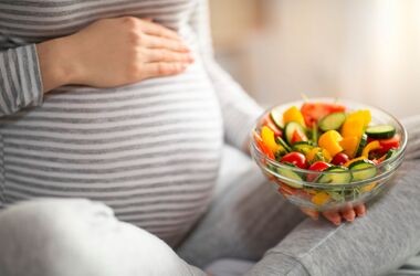 dieta w ciąży, czego nie jeść w ciąży - lista produktów, kobieta w ciąży trzyma miskę z sałatką