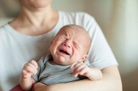 matka trzyma płaczące niemowlę