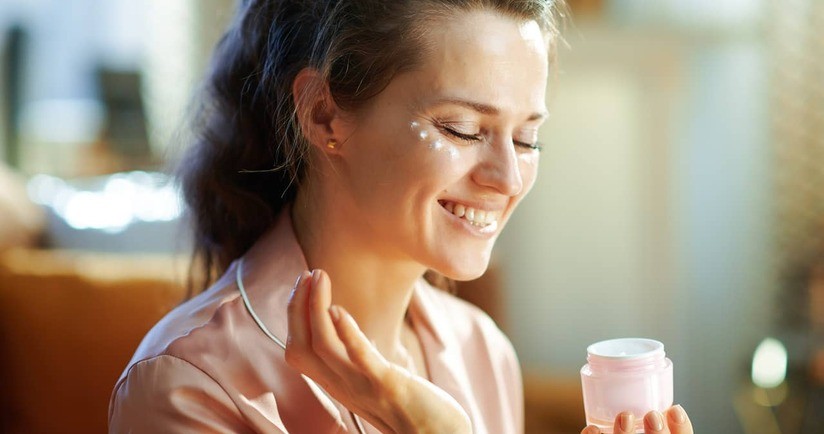 kobieta smaruje się kremem z antyoksydantami