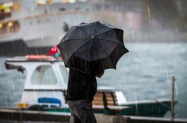 człowiek z parasolem idzie w deszczu
