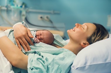 Matka po porodzie pierwszy raz przytula dziecko do ciała – kangurowanie