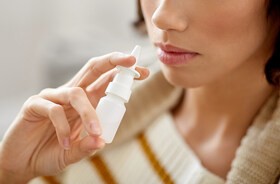 Kobieta aplikuje sobie lek przez aerozol do nosa
