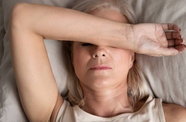 kobieta po menopauzie leżąca na łóżku