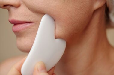 gua sha, masaż gua sha, kobieta wykonująca masaż twarzy kamieniem gua sha