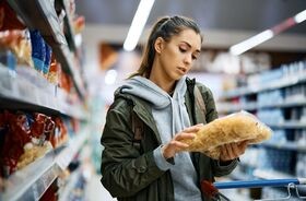 Młoda kobieta czytająca etykietę produktu. Dodatki do żywności, lista e, e w żywności, składniki e, dodatki e.