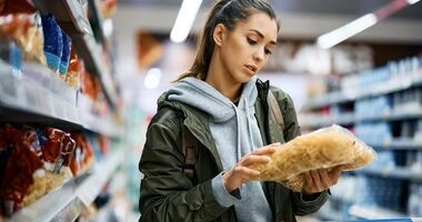 Młoda kobieta czytająca etykietę produktu. Dodatki do żywności, lista e, e w żywności, składniki e, dodatki e.