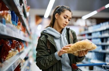 Młoda kobieta czytająca etykietę produktu. Dodatki do żywności, lista e, e w żywności, składniki e, dodatki e.