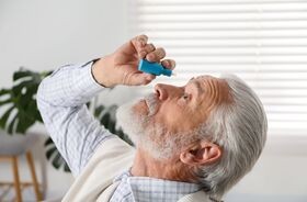 Mężczyzna z alergicznym zapaleniem spojówek zakrapla sobie oczy. zapalenie spojówek na tle alergicznym, alergiczne zapalenie spojówek objawy, co na alergiczne zapalenie spojówek